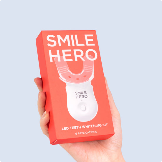 Girl holding Smile Hero's LED Teeth Whitening Kit at home