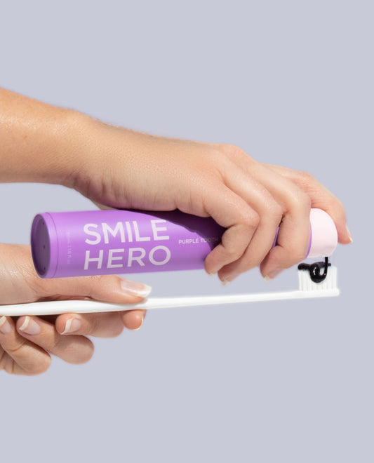 Smile Hero's Purple Tooth Toner being applied to toothbrush at home